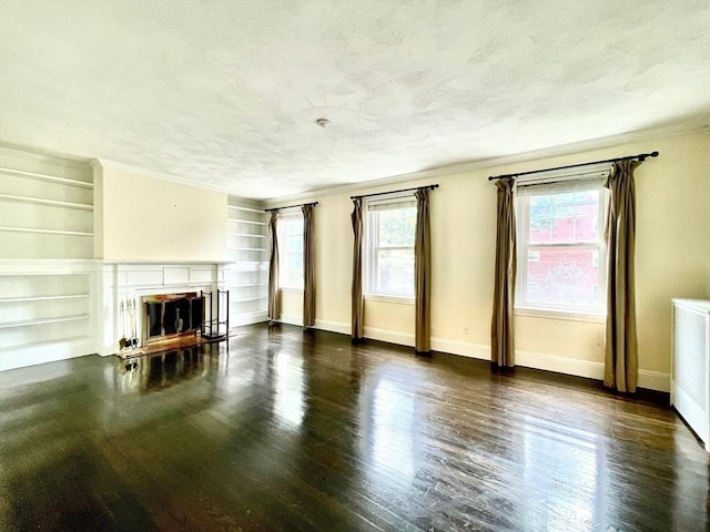 132 Sewall Ave Unit B, Brookline, MA 02446 - unfurnished living room featuring a fireplace, wood finished floors, built in features, a textured ceiling, and radiator heating unit