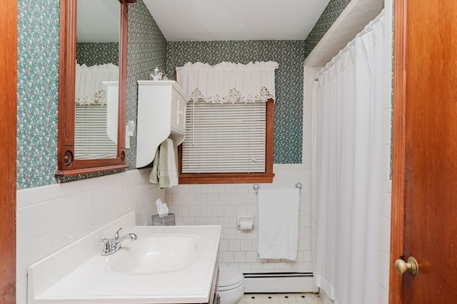 bathroom featuring vanity, a baseboard heating unit, tile patterned floors, tile walls, and toilet