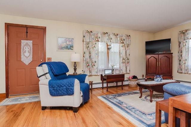 sitting room with a baseboard heating unit and light wood-type flooring