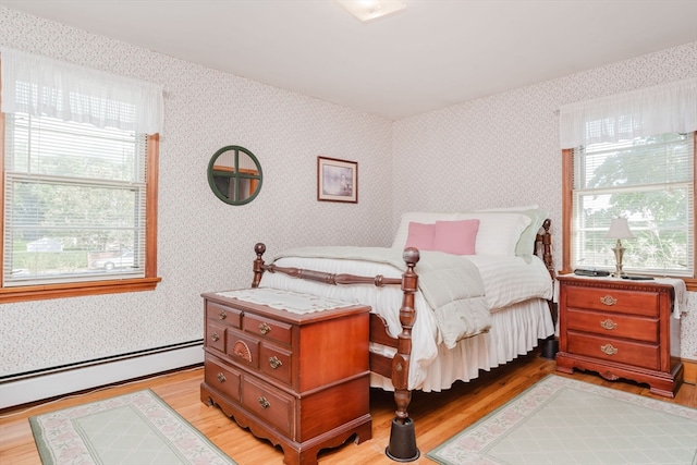 bedroom featuring a baseboard radiator and light hardwood / wood-style floors