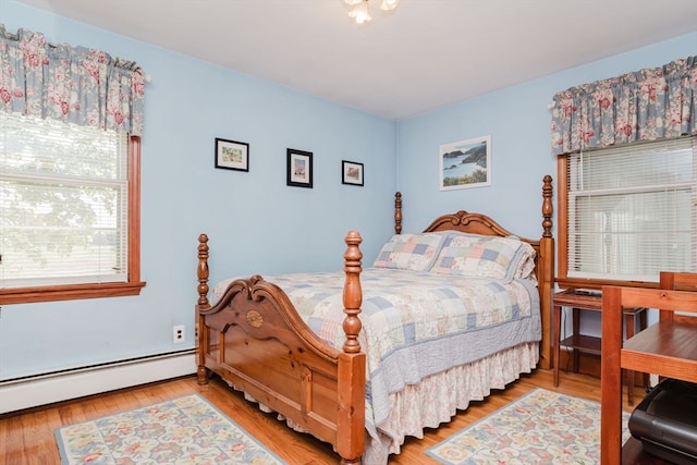 bedroom with baseboard heating and hardwood / wood-style floors