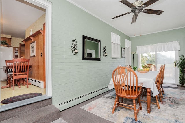 dining room featuring brick wall, crown molding, a baseboard heating unit, and ceiling fan