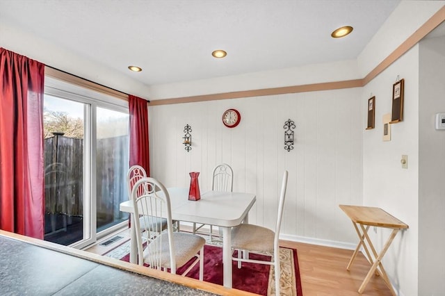 dining room with wood walls and hardwood / wood-style flooring