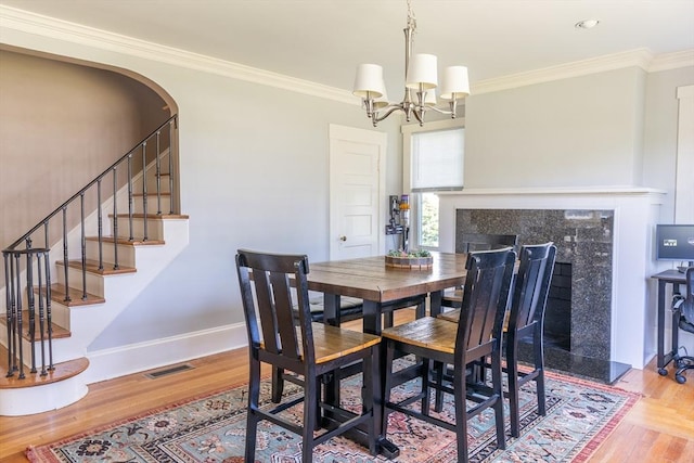 103 Maple Rd, Longmeadow, MA 01106 - dining space with a premium fireplace, wood finished floors, ornamental molding, a chandelier, and baseboards
