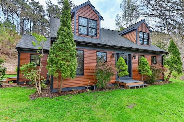 rear view of property featuring a lawn