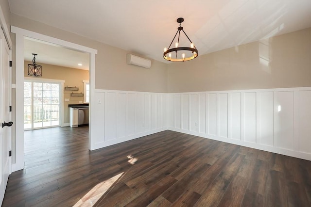 spare room with an inviting chandelier, dark hardwood / wood-style flooring, and a wall mounted air conditioner