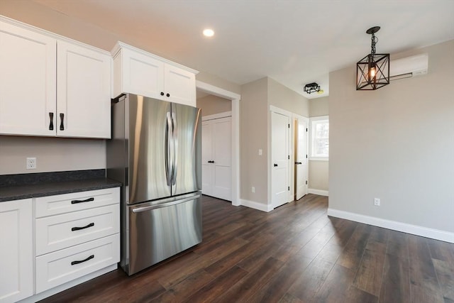 kitchen with dark hardwood / wood-style flooring, pendant lighting, white cabinets, and stainless steel fridge