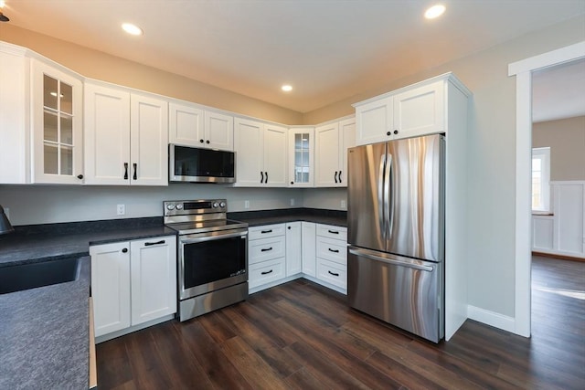 kitchen featuring appliances with stainless steel finishes, dark hardwood / wood-style flooring, and white cabinets