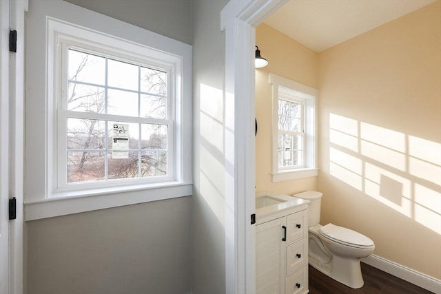 bathroom featuring hardwood / wood-style flooring, plenty of natural light, toilet, and vanity