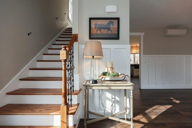 stairs featuring hardwood / wood-style flooring and a wall mounted air conditioner