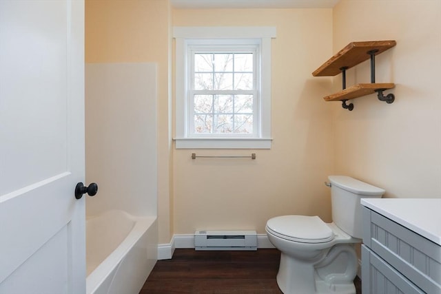 bathroom with toilet, a baseboard radiator, wood-type flooring, a bath, and vanity