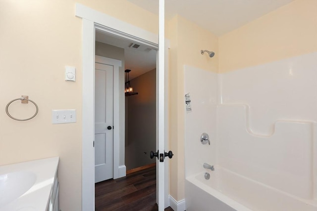 bathroom featuring shower / bathtub combination, sink, and hardwood / wood-style flooring