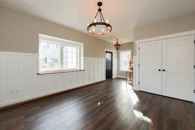 entryway featuring dark hardwood / wood-style flooring and a chandelier