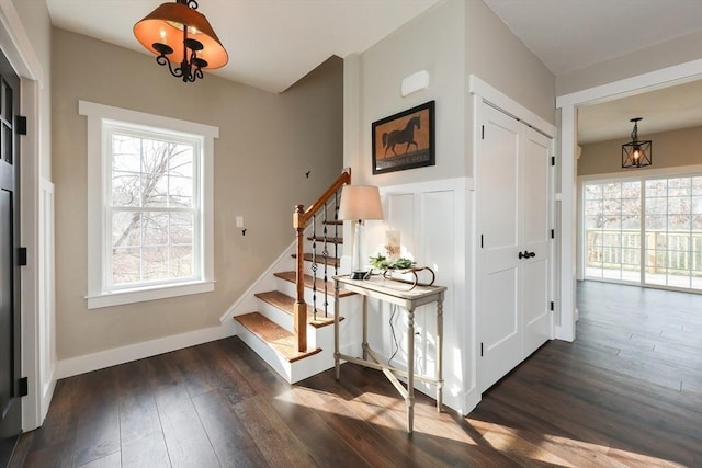 staircase with a notable chandelier and hardwood / wood-style flooring