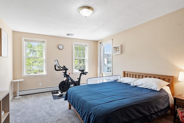 carpeted bedroom with baseboard heating and baseboards