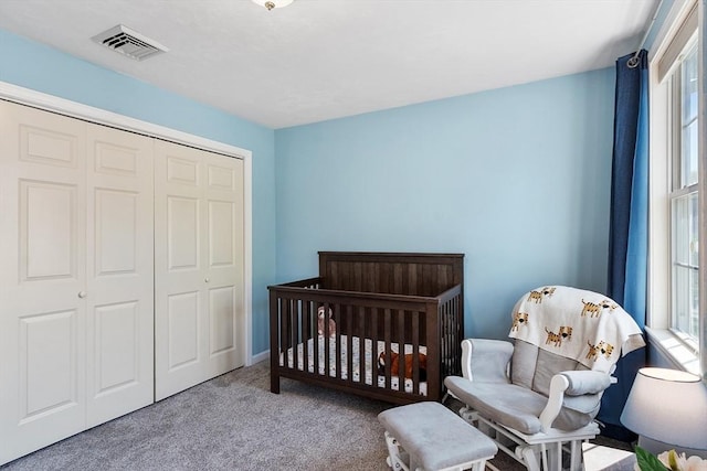 bedroom featuring carpet floors, a closet, and a nursery area