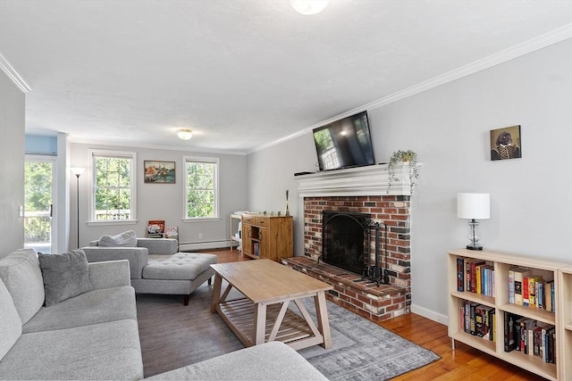living area featuring a baseboard heating unit, crown molding, wood finished floors, a fireplace, and baseboards