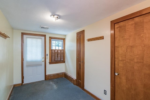 doorway featuring carpet, visible vents, and baseboards