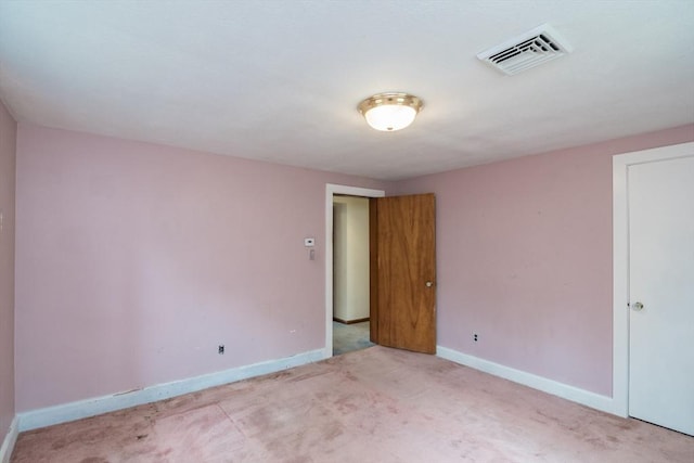 carpeted spare room with visible vents and baseboards
