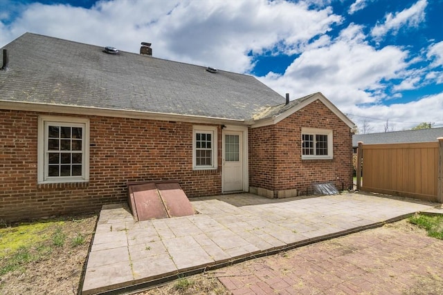 back of property featuring a patio, fence, and brick siding