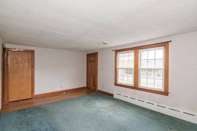 unfurnished room featuring baseboards, carpet floors, and a baseboard radiator