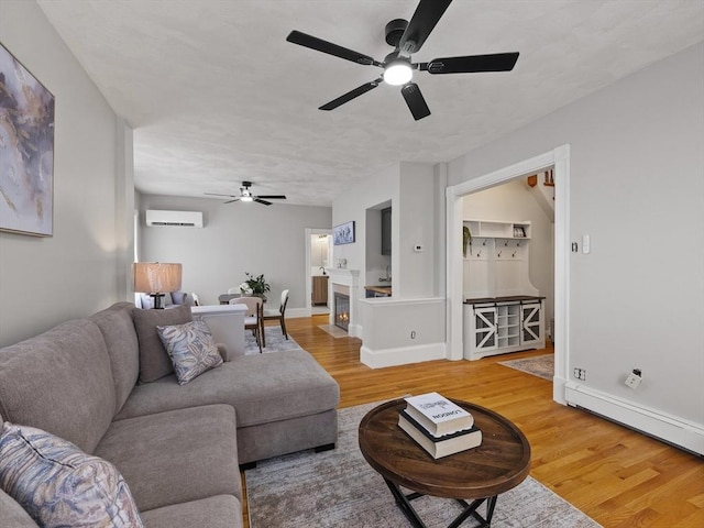 34 Rockland St, Melrose, MA 02176 - living area featuring ceiling fan, a wall mounted air conditioner, light wood-type flooring, and baseboard heating