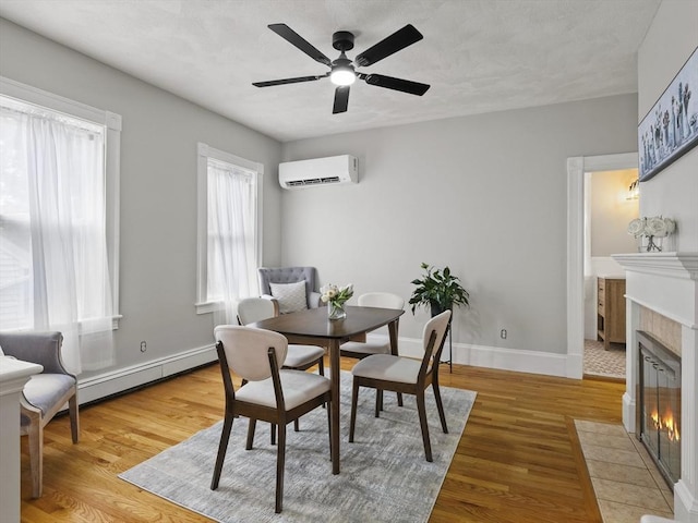 34 Rockland St, Melrose, MA 02176 - dining room featuring an AC wall unit, a fireplace, a baseboard heating unit, and light wood-type flooring