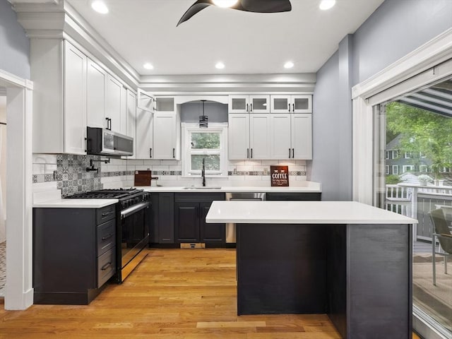 34 Rockland St, Melrose, MA 02176 - kitchen featuring appliances with stainless steel finishes, a ceiling fan, light countertops, white cabinetry, and decorative backsplash