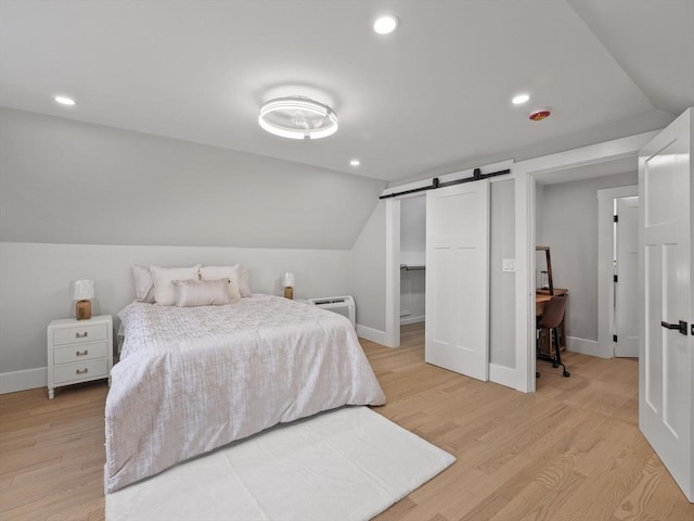 34 Rockland St, Melrose, MA 02176 - bedroom featuring light wood-type flooring, vaulted ceiling, recessed lighting, a wall unit AC, and a barn door