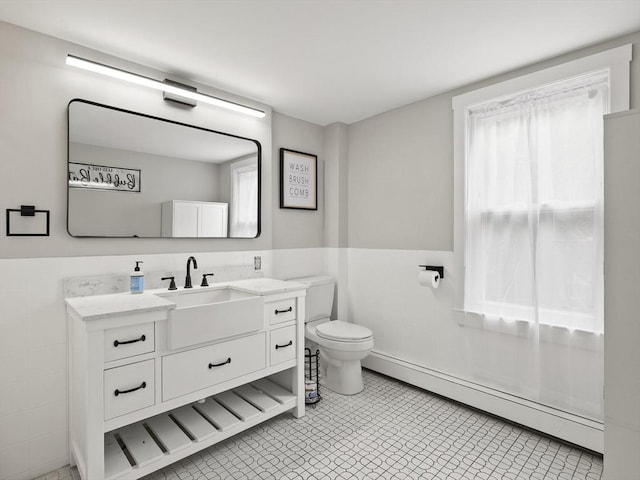 34 Rockland St, Melrose, MA 02176 - bathroom featuring a baseboard heating unit, vanity, a wainscoted wall, and tile walls