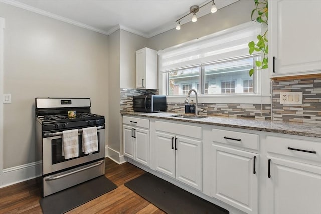 kitchen featuring black microwave, a sink, white cabinetry, gas range, and backsplash