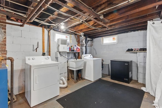 below grade area featuring separate washer and dryer, refrigerator, and a sink