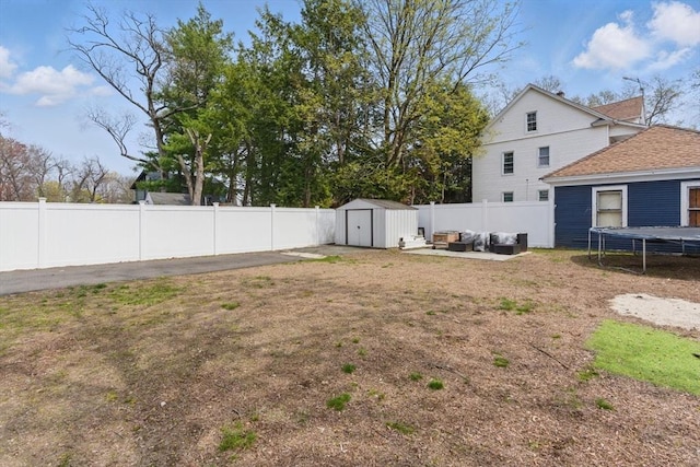view of yard with a trampoline, a storage shed, an outdoor structure, a fenced backyard, and an outdoor hangout area