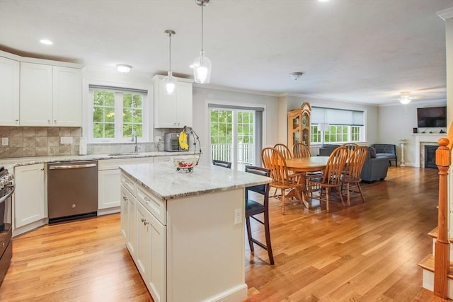 11 Bigelow Dr Unit 11, Berlin, MA 01503 - kitchen featuring stainless steel dishwasher, a kitchen breakfast bar, healthy amount of natural light, tasteful backsplash, and crown molding