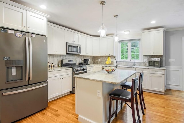 11 Bigelow Dr Unit 11, Berlin, MA 01503 - kitchen with stainless steel appliances, a kitchen breakfast bar, white cabinets, a sink, and crown molding