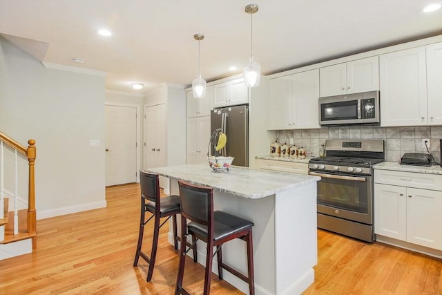 11 Bigelow Dr Unit 11, Berlin, MA 01503 - kitchen with stainless steel appliances, crown molding, a breakfast bar area, backsplash, and white cabinetry