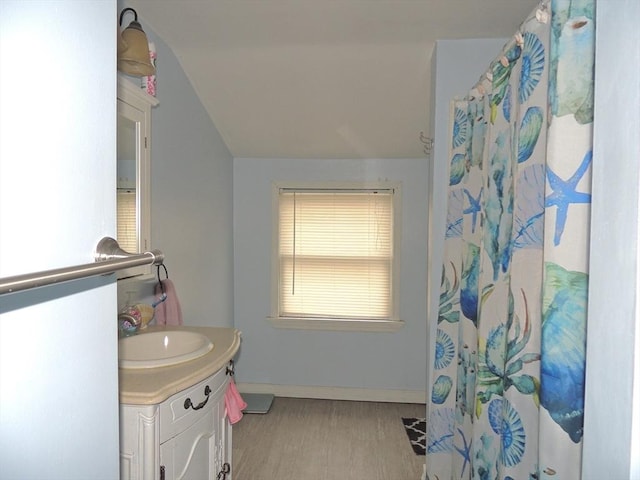 bathroom featuring hardwood / wood-style floors, vanity, and lofted ceiling