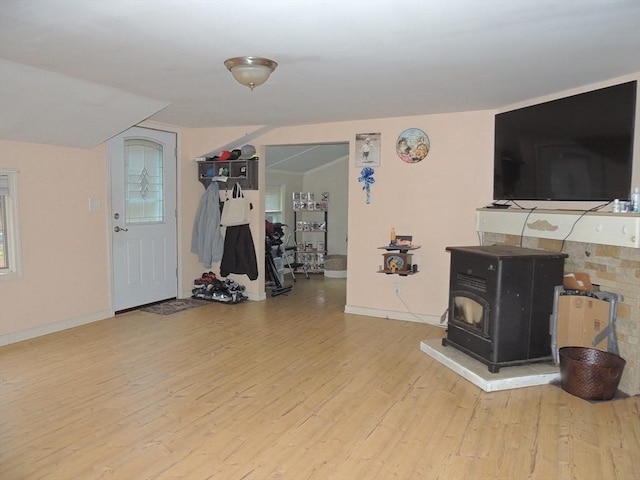 workout room featuring hardwood / wood-style flooring and a wood stove