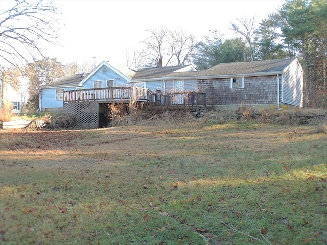 rear view of property featuring a lawn and a wooden deck