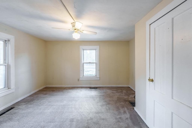 carpeted spare room with ceiling fan