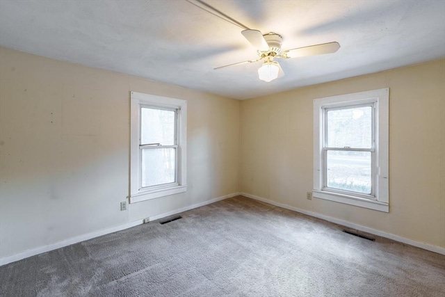 spare room with ceiling fan, carpet flooring, and a wealth of natural light