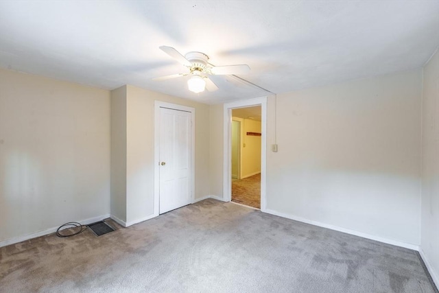 carpeted spare room with ceiling fan