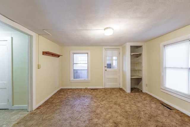 unfurnished bedroom with light carpet and a textured ceiling