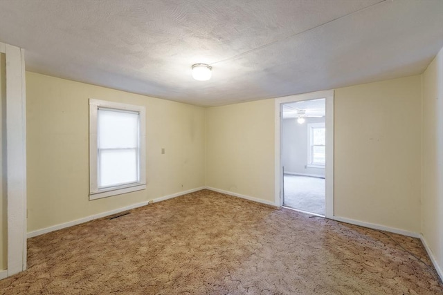 carpeted spare room featuring a textured ceiling