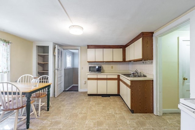 kitchen with tasteful backsplash, sink, plenty of natural light, and stove