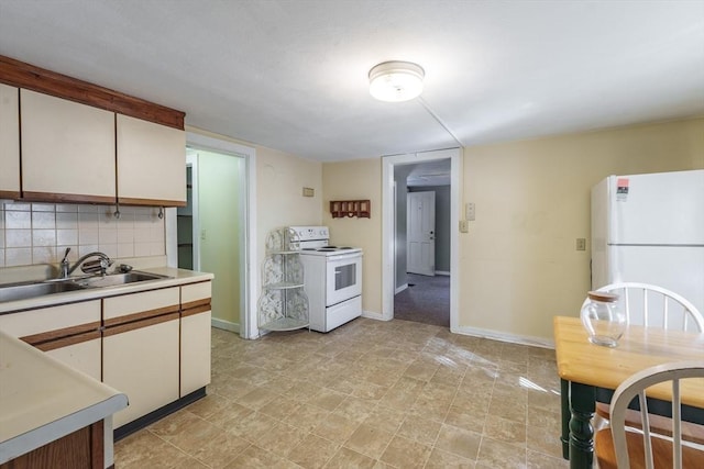 kitchen with white cabinetry, sink, white appliances, and decorative backsplash