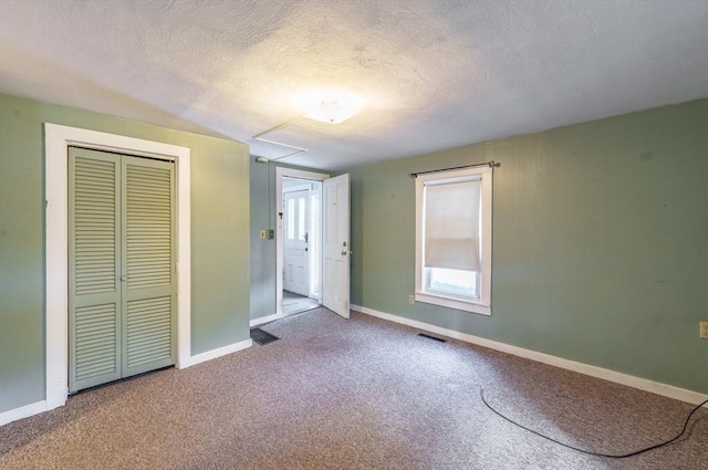 unfurnished bedroom featuring a closet, carpet, and a textured ceiling