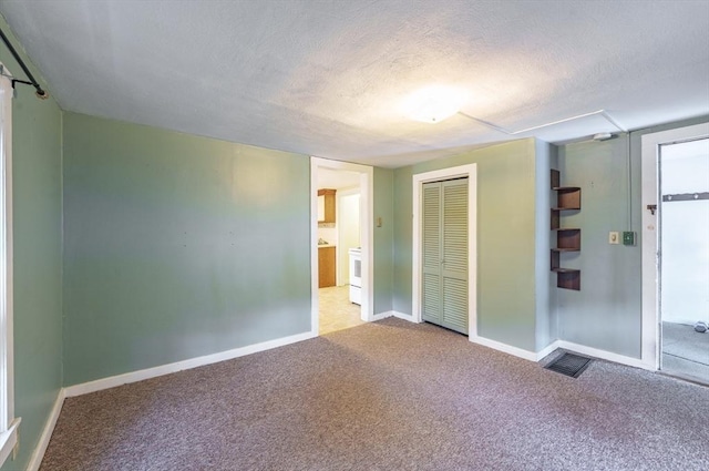 unfurnished bedroom with carpet flooring, connected bathroom, a textured ceiling, and a closet