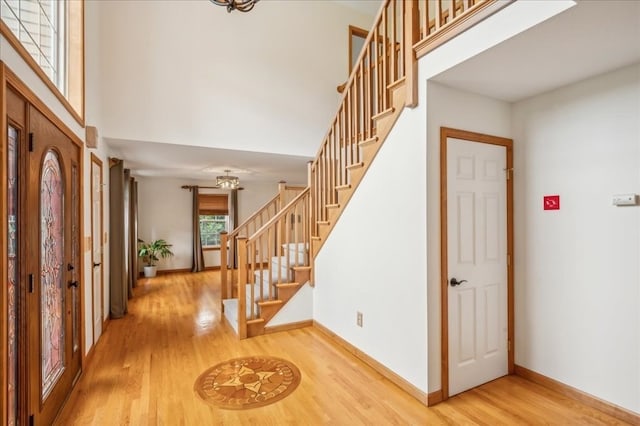 entryway with light hardwood / wood-style flooring and a high ceiling