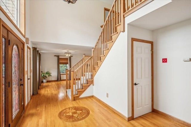 foyer with a towering ceiling and hardwood / wood-style flooring